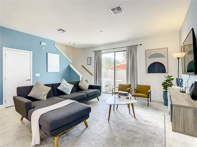 a kitchen with stainless steel appliances kitchen island granite countertop a sink a stove a refrigerator and a dining table