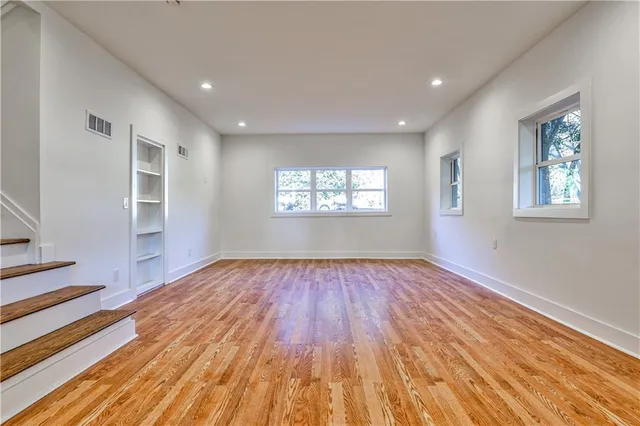 a view of an empty room window and wooden floor