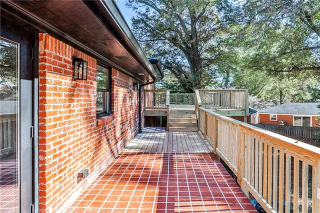 a view of a balcony with wooden floor and fence