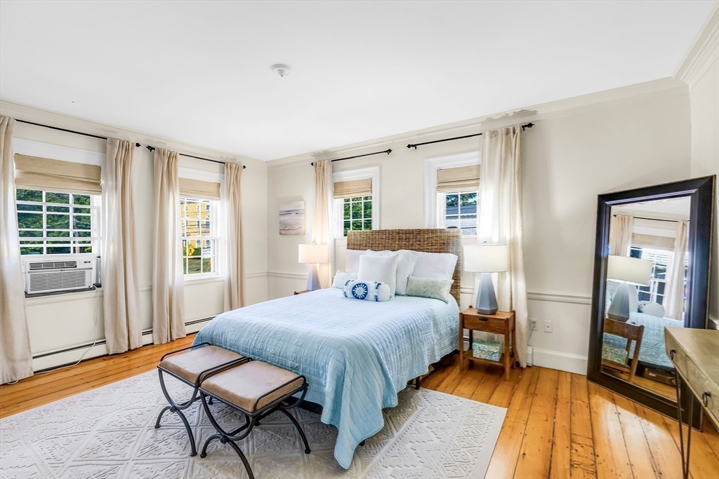 138 State Street, Unit 1 Newburyport, MA 01950 - Photo 21 of 35 a bedroom with a bed and wooden floor