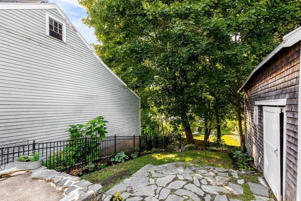 138 State Street, Unit 1 Newburyport, MA 01950 - Photo 31 of 35 a view of a backyard with plants and large tree