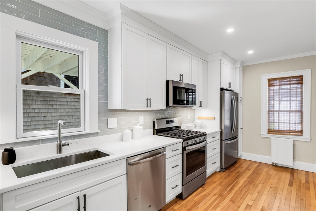 138 State Street, Unit 1 Newburyport, MA 01950 - Photo 7 of 35 a kitchen with granite countertop a sink stainless steel appliances a counter space and cabinets