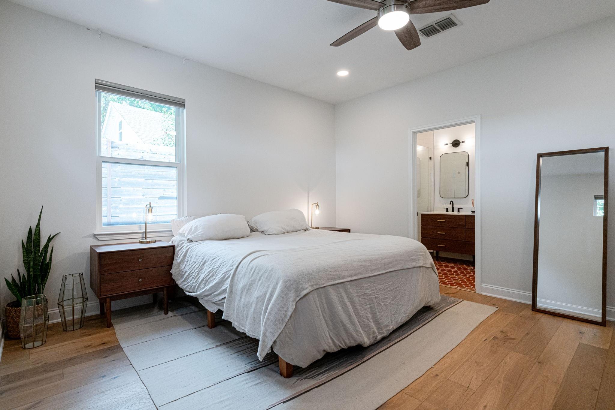 72 San Saba Street Austin, TX 78702 - Photo 11 of 23 Bedroom with light wood finished floors, a ceiling fan, connected bathroom, and recessed lighting