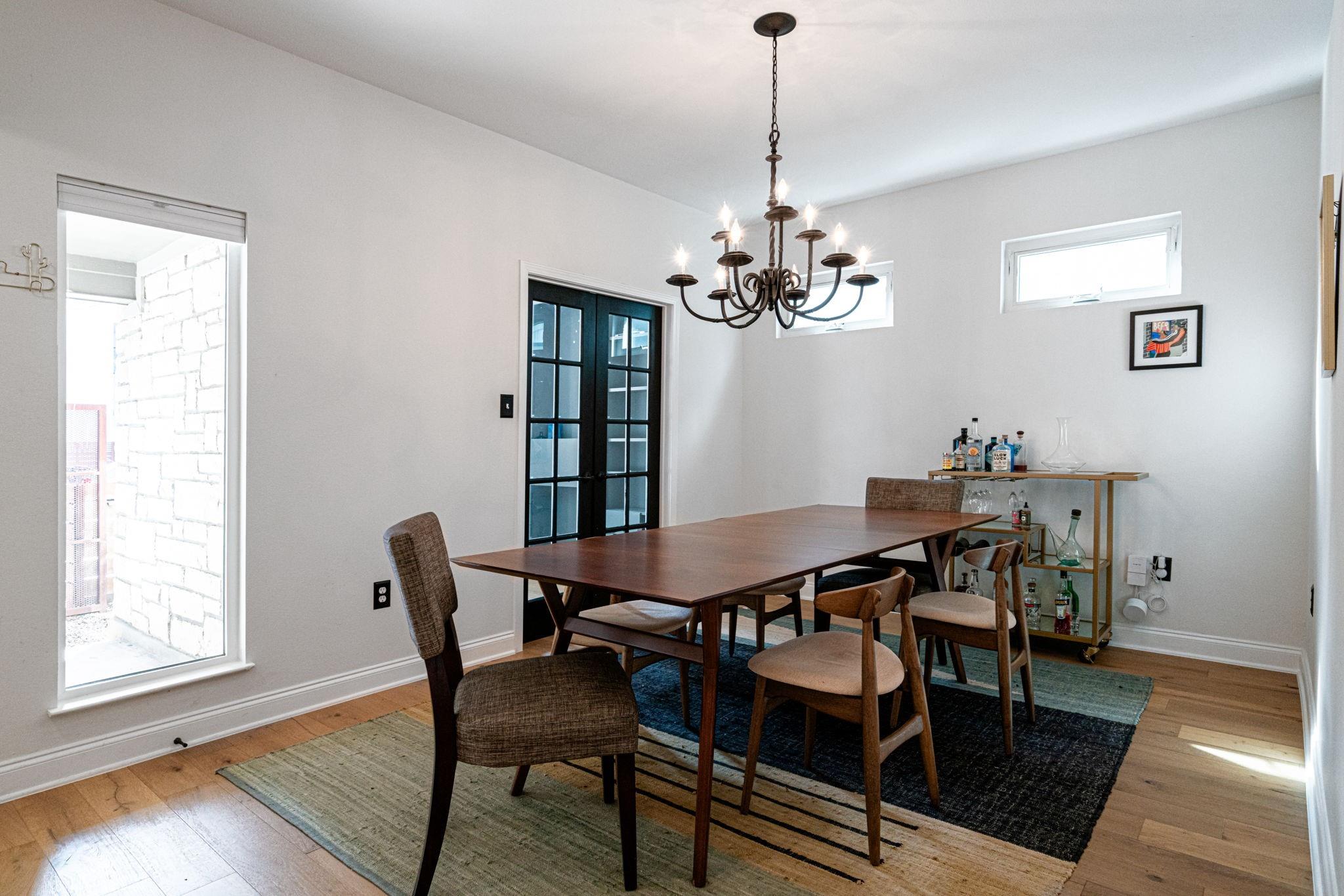 72 San Saba Street Austin, TX 78702 - Photo 6 of 23 Dining area featuring suspended lighting, light wood-style flooring, and french doors