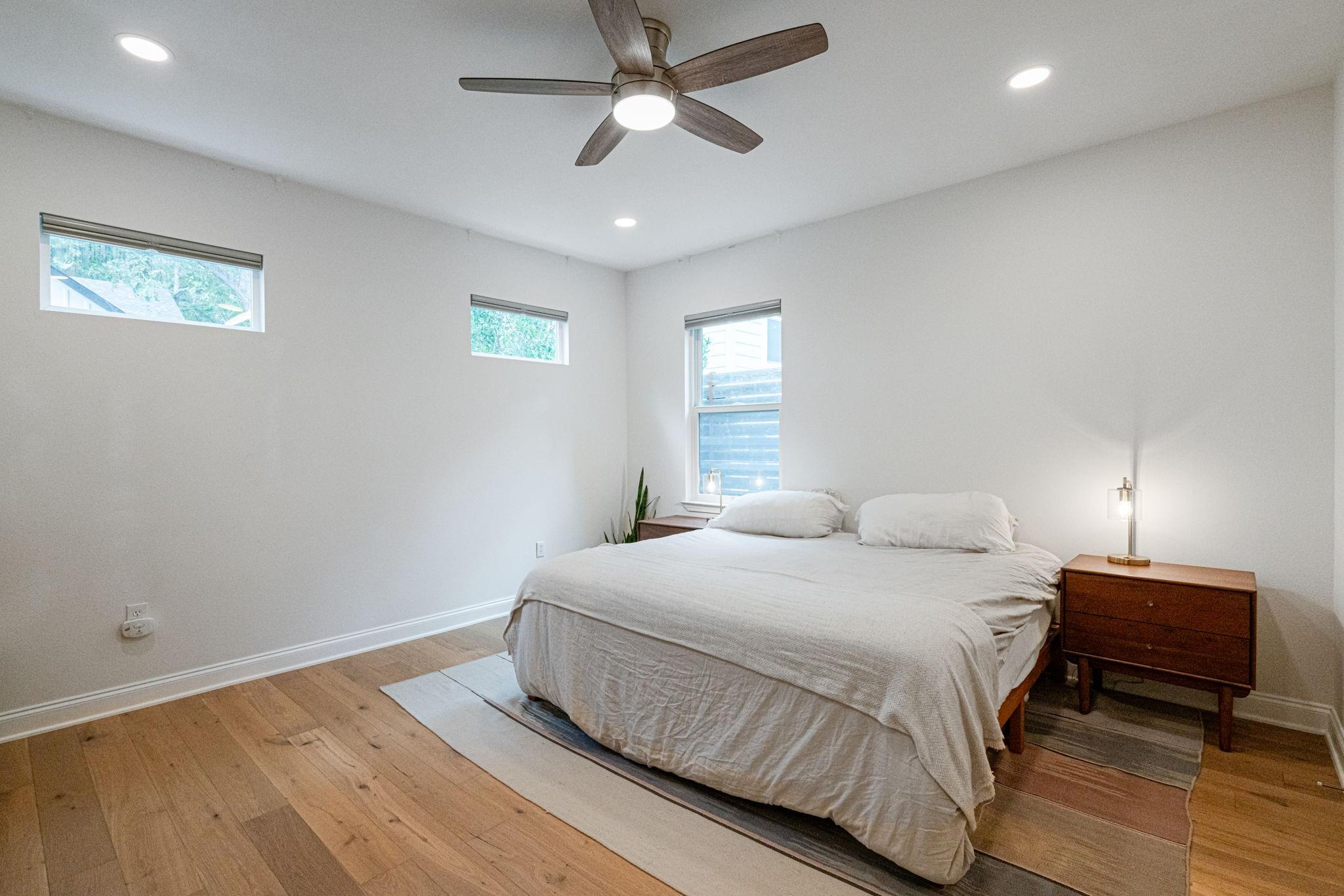 72 San Saba Street Austin, TX 78702 - Photo 10 of 23 Bedroom featuring light wood finished floors, a ceiling fan, and recessed lighting