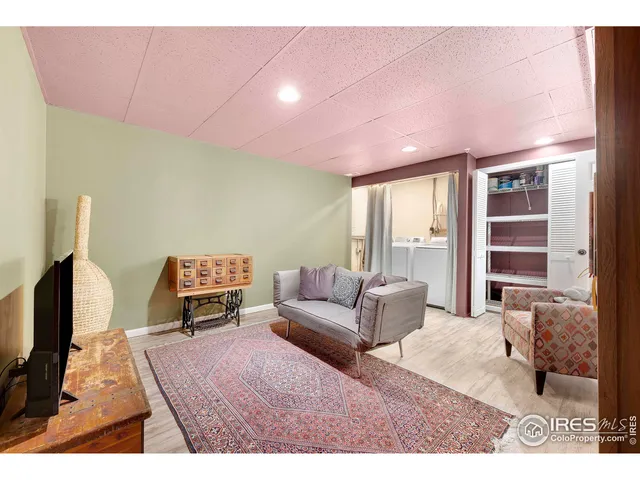 a living room with furniture a flat screen tv and a floor to ceiling window