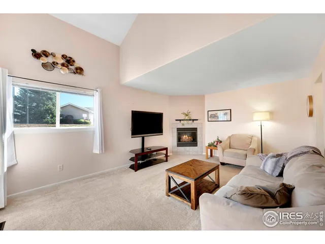 a living room with furniture a flat screen tv and a window