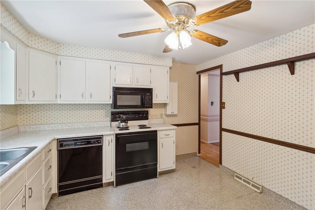 211 Wyngate Road Coraopolis, PA 15108 - Photo 11 of 31 a kitchen with stainless steel appliances granite countertop a refrigerator a stove a sink and white cabinets