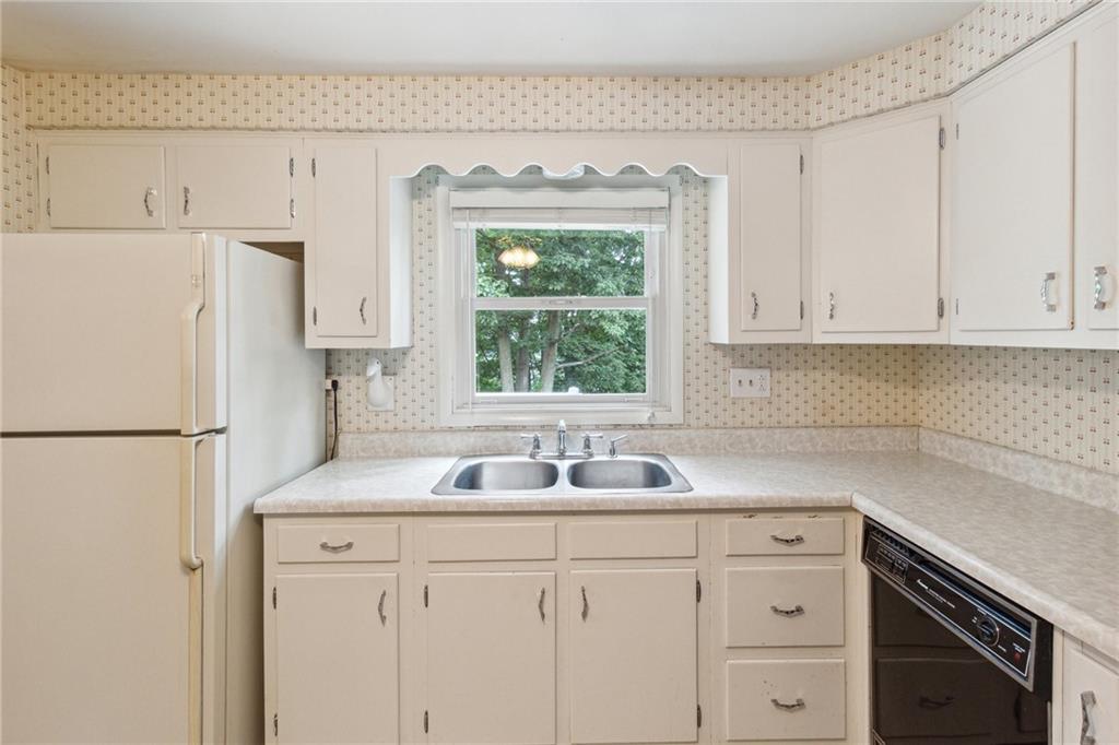 211 Wyngate Road Coraopolis, PA 15108 - Photo 14 of 31 a kitchen with a sink a refrigerator a window and cabinets