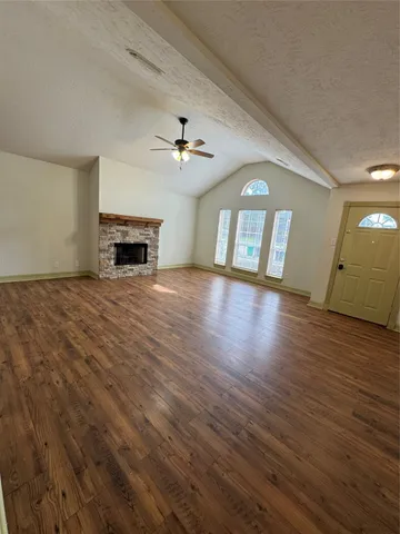 an empty room with wooden floor and fireplace