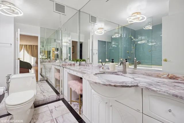 a bathroom with a granite countertop sink a toilet and a mirror