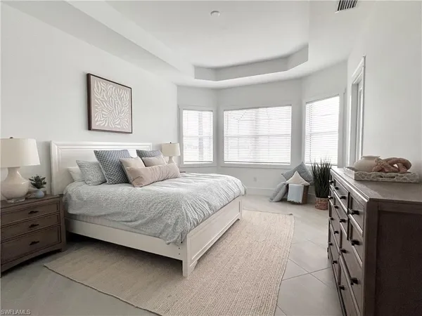 a spacious bedroom with a bed and a window