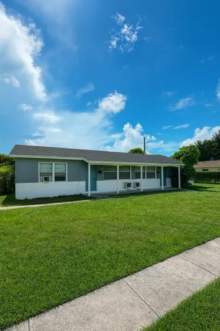 a yellow house with garden in front of it