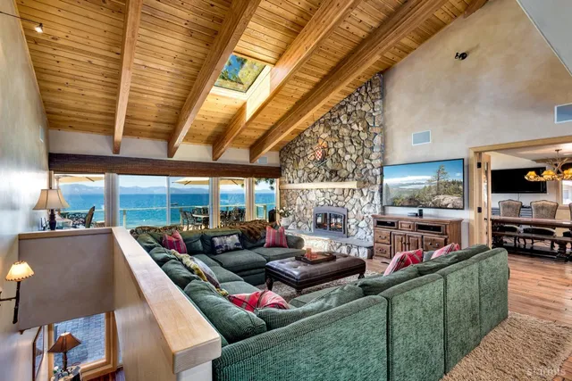 a living room with furniture a flat screen tv and a floor to ceiling window