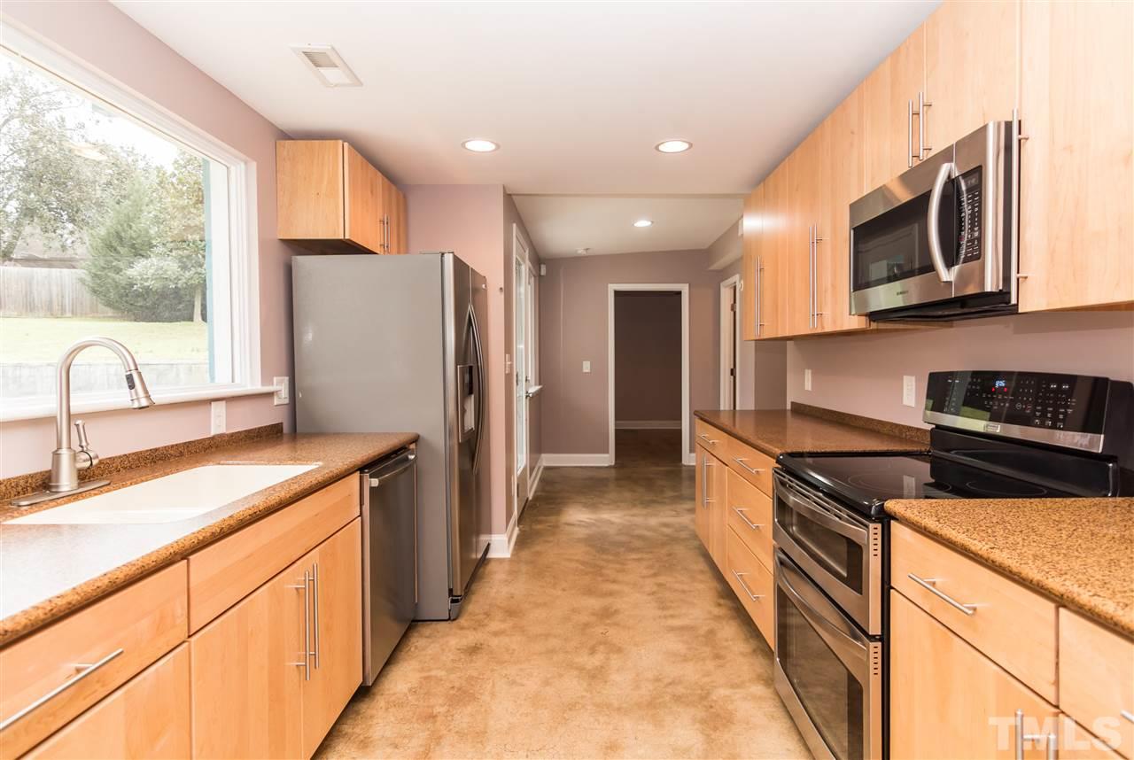 107 King William Road Raleigh, NC 27610 - Photo 9 of 25 a kitchen with stainless steel appliances granite countertop a stove a sink and a refrigerator