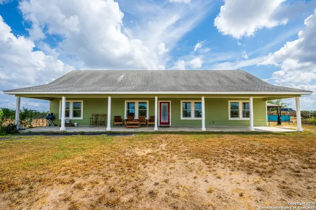 a view of a house with backyard and a tree