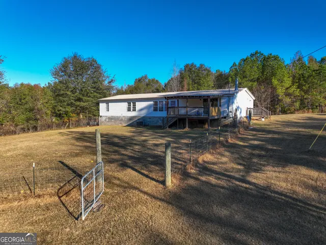 a view of a house with backyard and sitting area