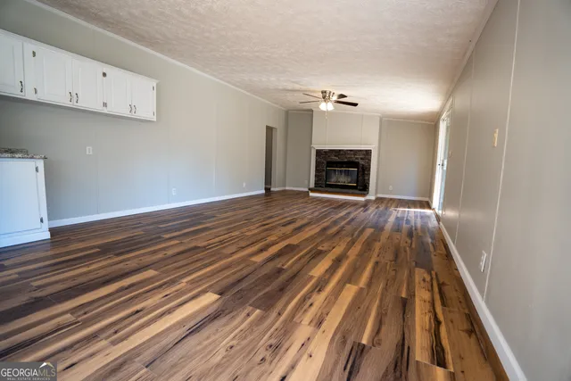 a view of empty room with wooden floor