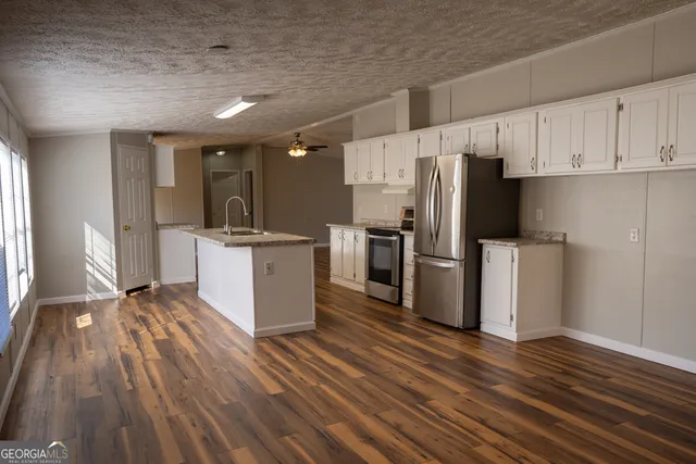 a kitchen with stainless steel appliances a refrigerator sink and cabinets