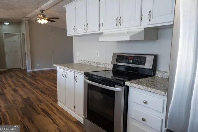 a kitchen with granite countertop cabinets stainless steel appliances and wooden floor