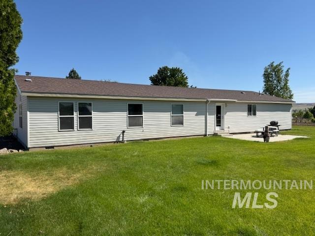 1095 County Road 70 Weiser, ID 83672 - Photo 6 of 44 Expansive rear exterior featuring white siding, multiple windows, a brown shingle roof, and a concrete patio