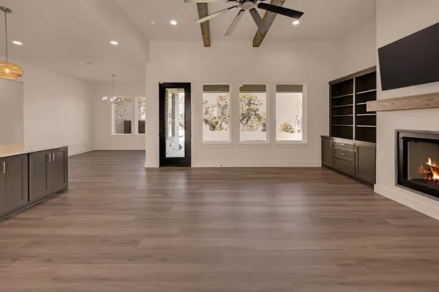 a view of a livingroom with wooden floor and a fireplace