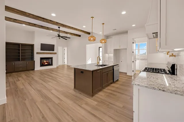 a large kitchen with stainless steel appliances granite countertop a stove oven and a wooden floors