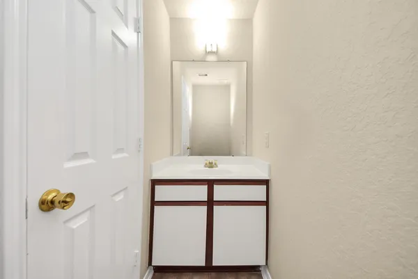 a bathroom with a granite countertop sink and mirror