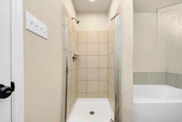 a bathroom with a tub shower and a sink