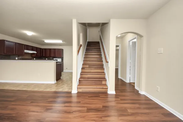 a view of a kitchen with wooden floor and stairs