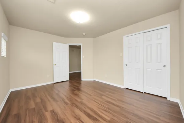 a view of an empty room with wooden floor