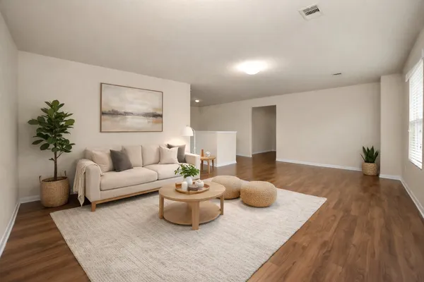 a living room with furniture and a wooden floor