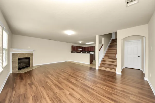 an empty room with wooden floor and fireplace