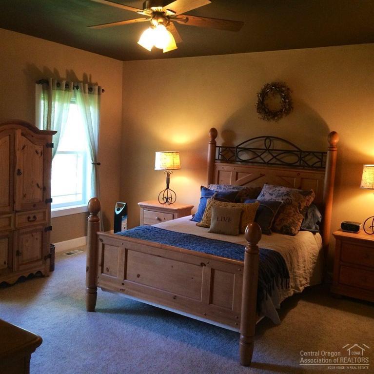 60670 Billadeau Road Bend, OR 97702 - Photo 18 of 25 a bedroom with a bed and a chandelier