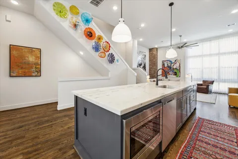 a kitchen with a sink a stove and a wooden floor