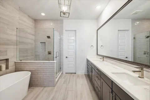 a bathroom with a double vanity sink a toilet a mirror and shower