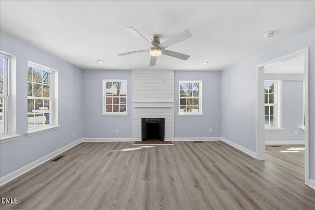 an empty room with windows and a fireplace