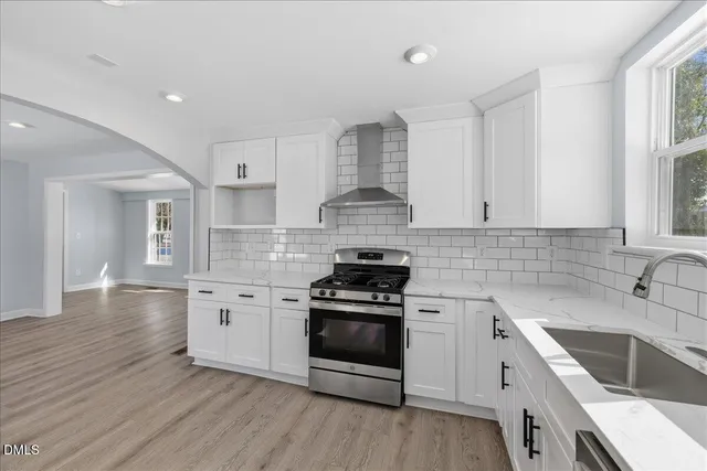 a kitchen with granite countertop a sink stainless steel appliances and cabinets