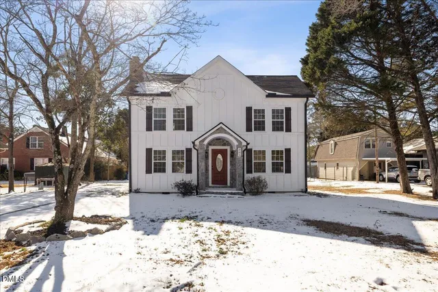 a front view of a house with a yard covered in snow