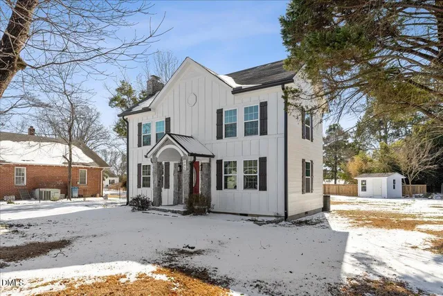a front view of a house with a yard covered in snow
