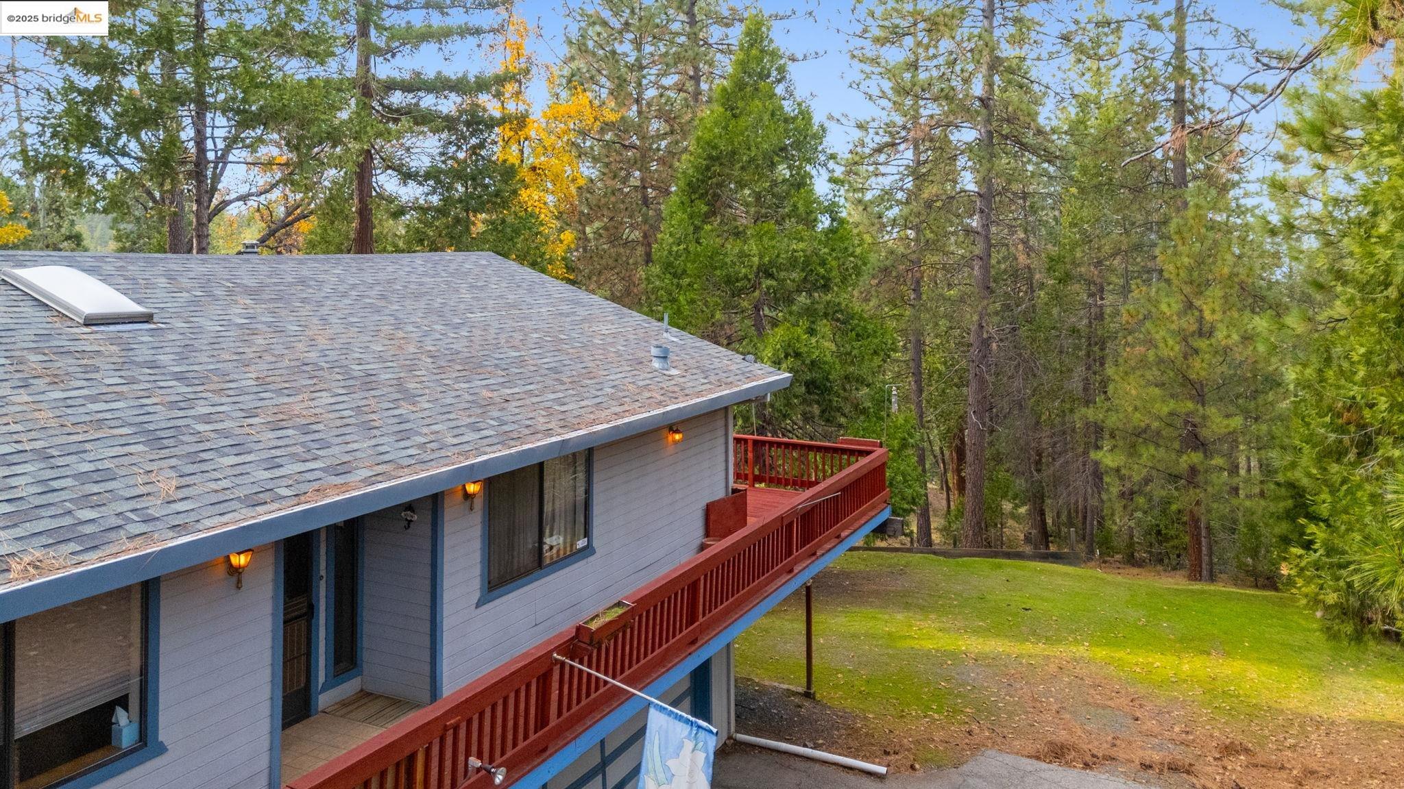 12087 Breckenridge Road Groveland, CA 95321 - Photo 29 of 31 View of home's exterior with a shingled roof, a lawn, and a deck