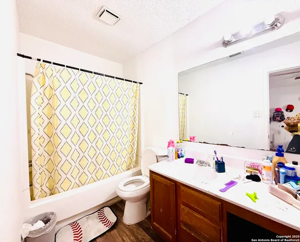 a bathroom with a sink vanity mirror and toilet