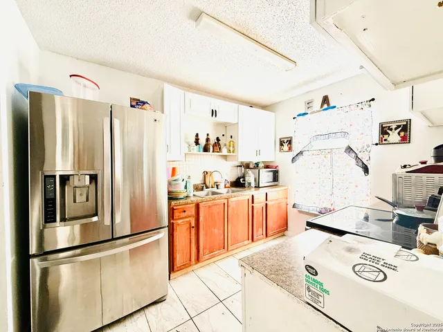 a kitchen with stainless steel appliances granite countertop a refrigerator sink stove and white cabinets