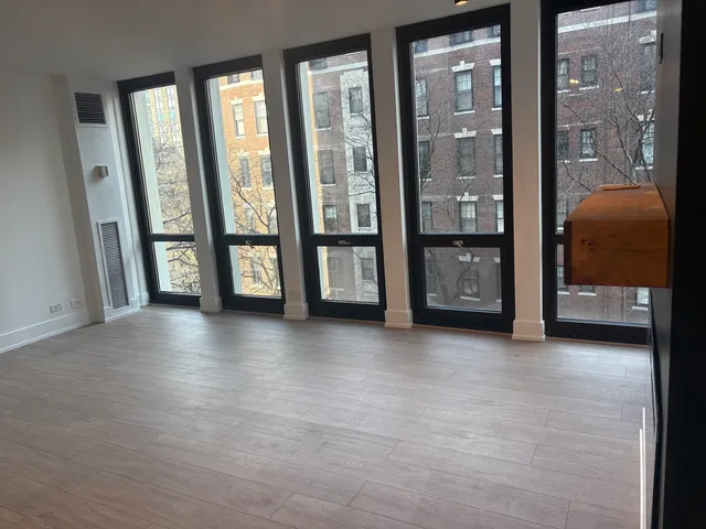 a view of an empty room with furniture and windows