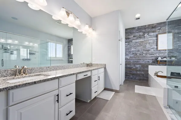 a bathroom with a sink a large mirror and a shower