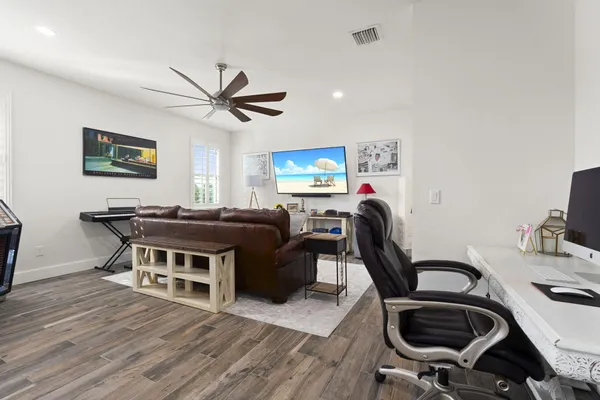 a work room with furniture a rug and a window
