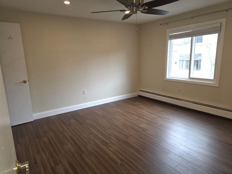 70 Mudge Street, Unit 12 Lynn, MA 01902 - Photo 11 of 22 an empty room with wooden floor fan and windows