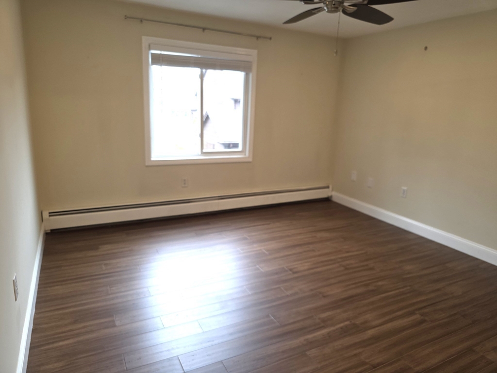 70 Mudge Street, Unit 12 Lynn, MA 01902 - Photo 13 of 22 an empty room with wooden floor and windows