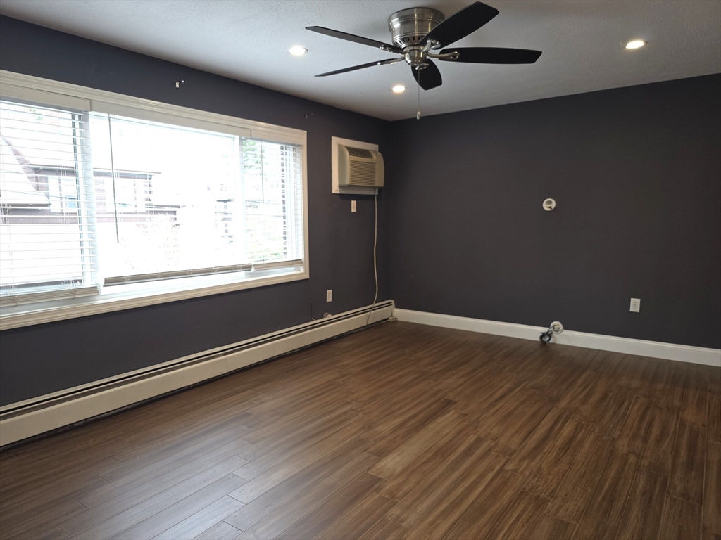 70 Mudge Street, Unit 12 Lynn, MA 01902 - Photo 6 of 22 an empty room with wooden floor and windows