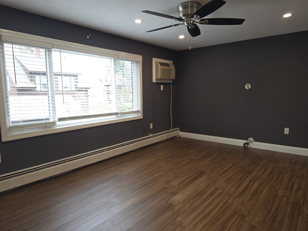 70 Mudge Street, Unit 12 Lynn, MA 01902 - Photo 7 of 22 a view of an empty room with wooden floor and a window